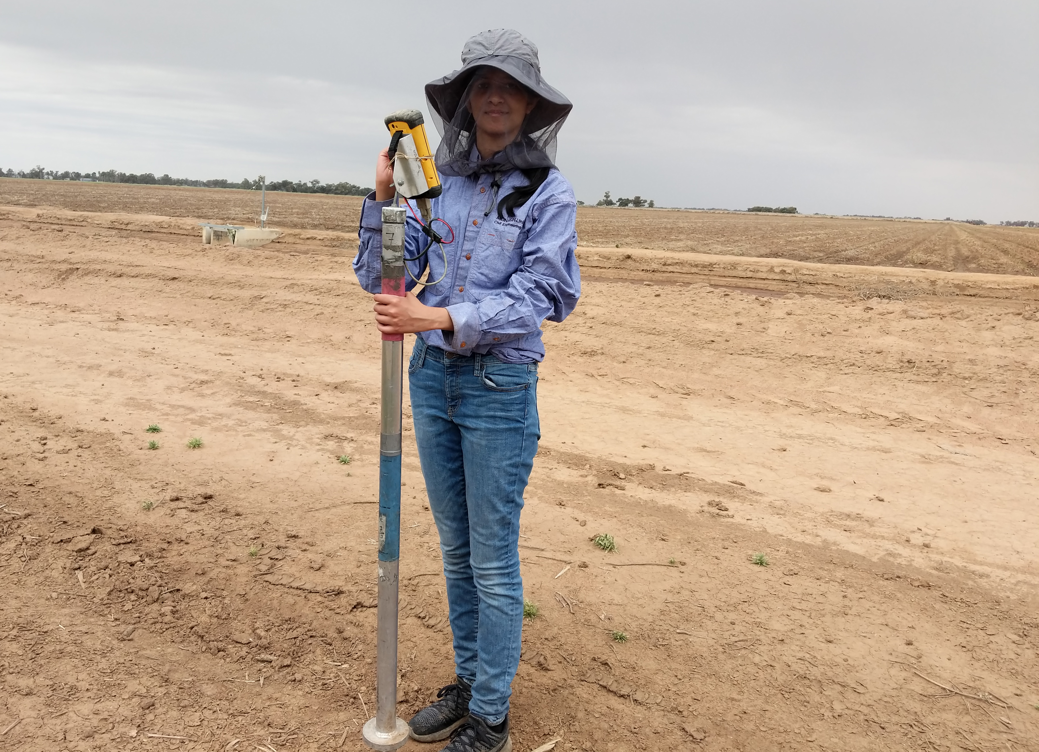 PhD student testing soil moisture in rural Australia